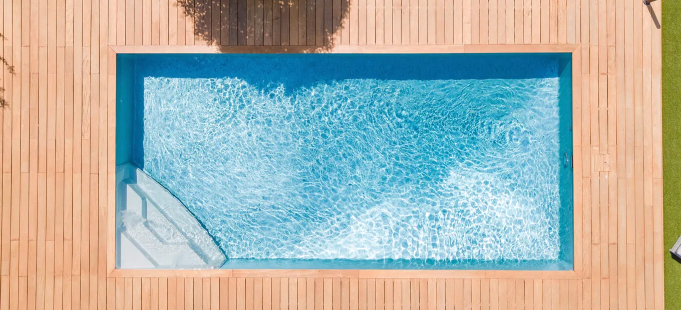 Piscina rettangolare con area a bordo vasca in legno